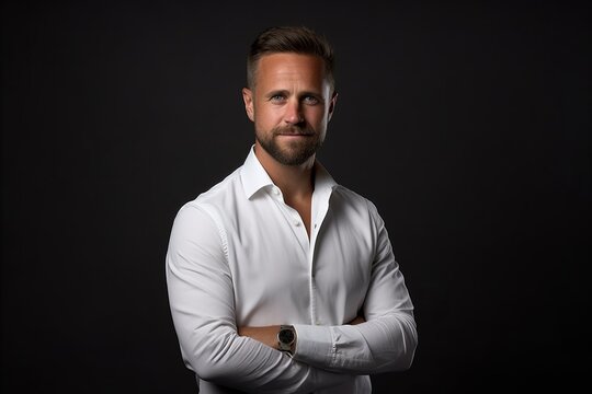 Portrait of a handsome man in a white shirt on a dark background.