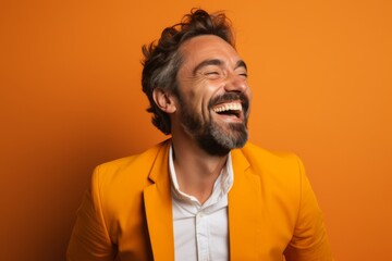 Portrait of a handsome man laughing, isolated on orange background.