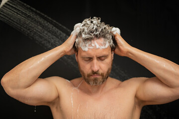 Man washing hair in bath. Guy bathing shower head in bathtub. Face in foam in shower. Bathing man taking shower. Close up guy showering. Shower concept. Man is under water drops in showers.