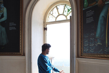 person looking out old window