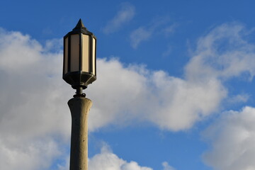 Fototapeta na wymiar City lighting, fancy concrete and glass pole, against beautiful blue sky.