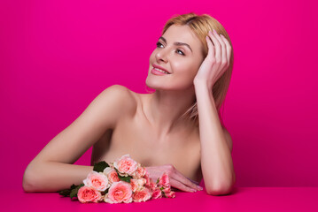 Obraz na płótnie Canvas Romantic dating or proposal. Portrait of attractive lovely charming dreamy girl holding pink roses, isolated on pink studio background.