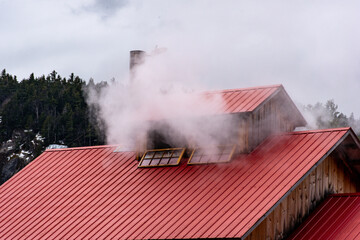 maple scented steam billowing from NH sugarhouse cupola with red metal roof