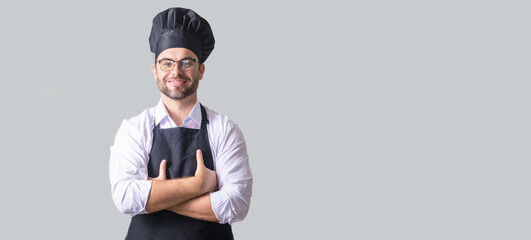 Handsome bearded male chef cook or baker man in uniform shirt posing isolated on yellow background,...