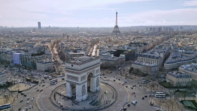 Triumphal arch or Arc de Triomphe with Tour Eiffel, Montparnasse tower and La Defense skyscrapers in background, Paris cityscape, France. Aerial sideways