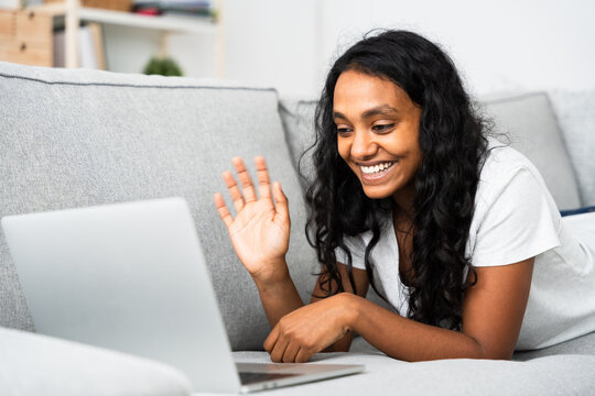 Indian teenager greeting on a video call. Young woman talking on laptop