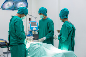 Medical team doing critical operation. Group of surgeons in operating room with surgery equipment...