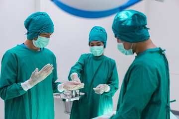 Fototapeta na wymiar Medical team doing critical operation. Group of surgeons in operating room with surgery equipment at hospital.