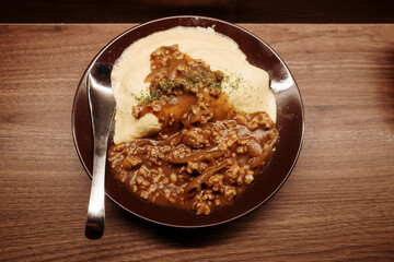 Top view of Omurice, omelet and rice, with curry on the wooden counter.