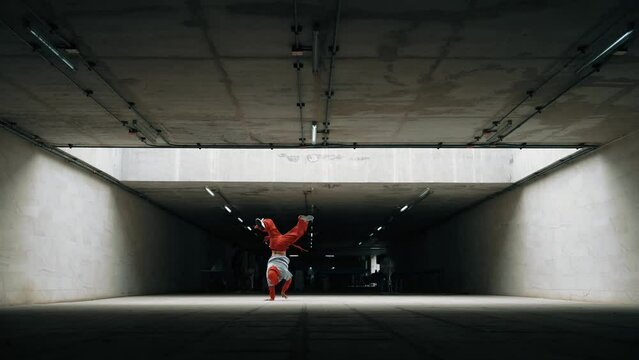 Long shot of handsome hipster perform lively and energetic movement. Freestyle dancer show break dance or street dance at building. Handsome choreographer show movement. Outdoor sport 2024. Sprightly.