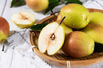 fresh ripe pears with half on wooden table.