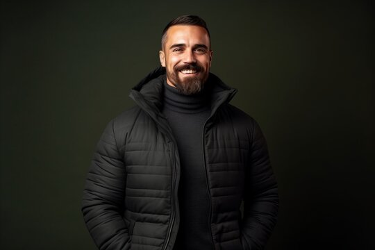 Portrait of a handsome bearded man in black jacket on dark background