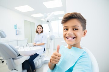 
Portrait of a smiling young boy, around 12 years old, of Hispanic descent, giving a thumbs-up sign after a successful dental procedure to alleviate toothache, with the dentist's figure intentionally  - obrazy, fototapety, plakaty