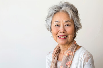 Fototapeta premium Portrait of old healthy, cheerful beautiful Asian woman smiling and looking at camera with white background. Happy aging society, retirement and senior healthcare concept