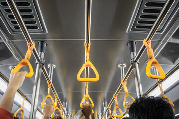Passengers on public transportation gripping handrail