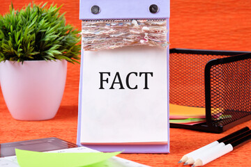 Fact Business Marketing Strategy Text Word written on the page of the desktop calendar on an orange background
