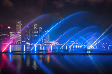 Night view of Singapore city sky with laser light