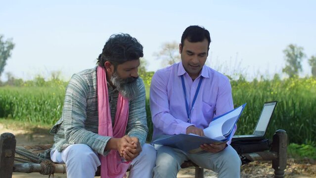 A young educated male with an old farmer - modern agricultural practices  better quality of crops  insurance agent  agri consultant. A village farmer discussing modern farming techniques - village ...