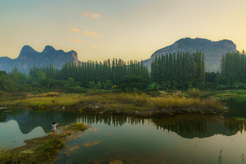 Sunrise sky over a tranquil lake nestled amidst lush mountains, reflecting the beauty of nature's calm