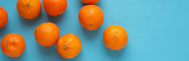 Fresh orange fruits banner with light blue background. Vibrant photo of citrus food top view....