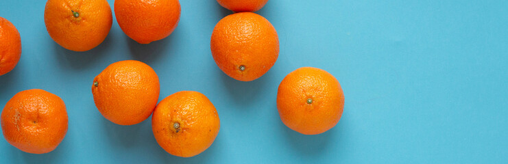 Fresh orange fruits banner with light blue background. Vibrant photo of citrus food top view. Vitamin C