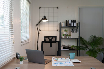 Modern workspace design with laptop computer, graph documents, and calculator for working in the office.