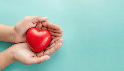 hands holding red heart on aqua background, heart health, donation, CSR concept, world heart - 752008760