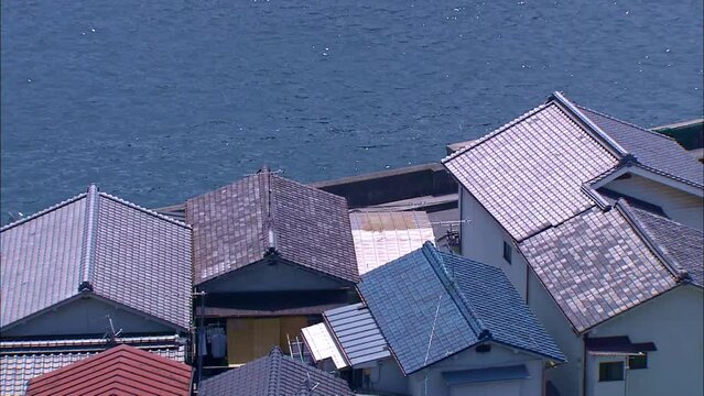 Traditional Japanese coastal town with tiled rooftops and Seto Inland Sea &ndash; Hiroshima, Japan