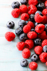 Blueberries and raspberries on wooden table