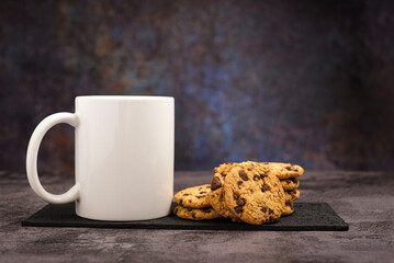 Vanilla chocolate chip cookies next to a white mug. Mockup.