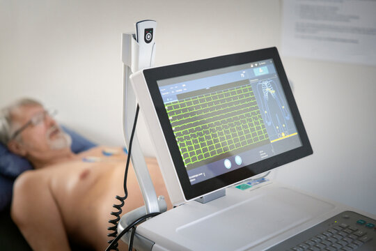 Computer monitor showing cardiac stress test results of elderly male patient in clinic