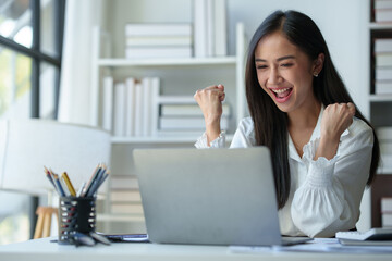 Asian businesswoman, office worker happy and cheerful while receiving recognition on laptop...