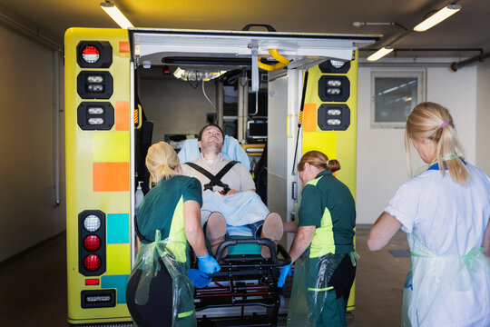 Female paramedics putting male patient in ambulance