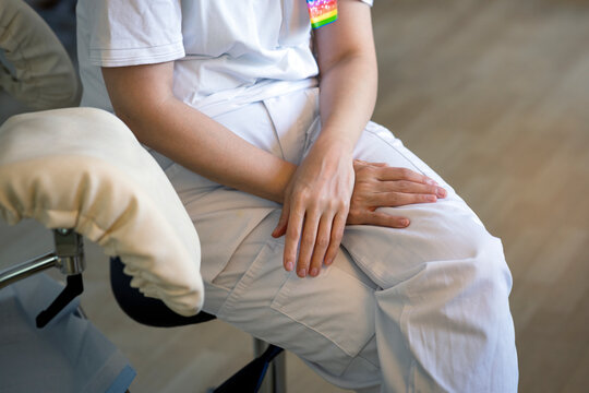 Midsection of female gynecologist sitting on chair in clinic