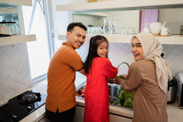 Fototapeta premium Portrait of a Muslim family cleaning vegetables for preparing food