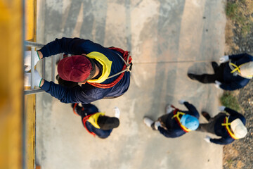 Firemen are practicing Move injured people from heights using ropes and ladders.