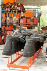 Row of shoes for firefighters There is a line of fire extinguishing equipment in the background.