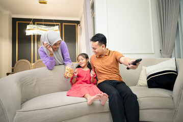 Asian family having good times in the living room sofa for entertainment or bonding at home.