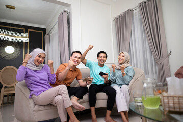 Portrait of young people sitting on the couch and playing games on mobile phones spending time together