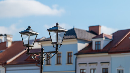 Fototapeta na wymiar Urban street lamp in retro style against the background of blurred tenement houses