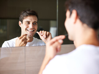 Happy man, teeth and dental care with floss for hygiene, grooming or freshness in bathroom mirror...