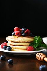 Pancakes with raspberries and blueberries with honey. Morning,pancakes for breakfast
