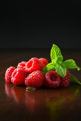 Fresh raspberries with mint on a dark background