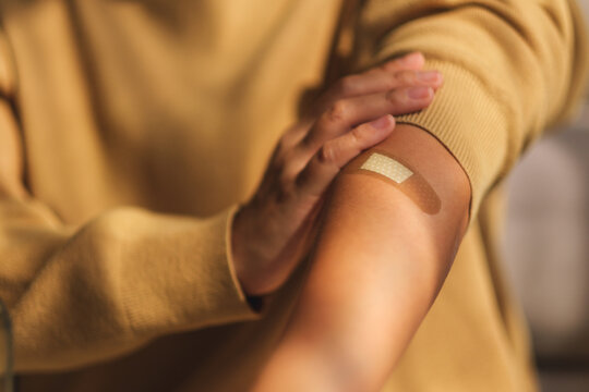 Closeup Image Of A Woman With Adhesive Bandage, Medical Plaster, Band Aid On Her Arm