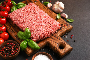 Minced pork and beef on a wooden board. Minced meat with spices on a dark background - 752040735