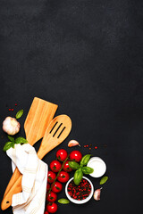 Spatula and kitchen towel and tomatoes on a black background. Food background - 752041576