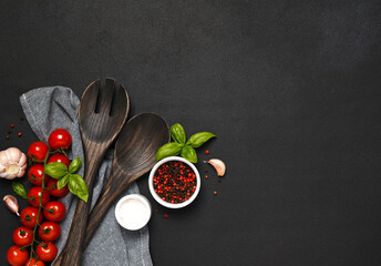 Spatula and kitchen towel and tomatoes on a black background. Food background - 752041746