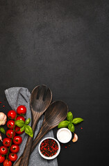 Spatula and kitchen towel and tomatoes on a black background. Food background - 752041790