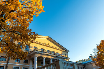 Fototapeta premium Yusupov Palace in St. Petersburg against the background of a blue sky and a crown of a tree with golden leaves