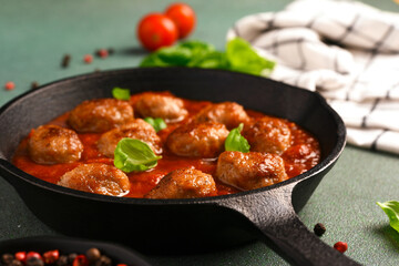 .Meatballs with tomato sauce and basil in a frying pan